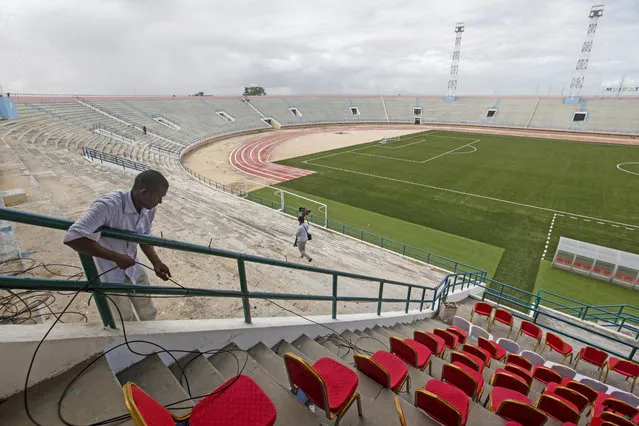 A man runs cables prior to the reopening of the soccer stadium in Mogadishu, Somalia Tuesday, June 30, 2020. At least three mortar blasts struck the Mogadishu Stadium Tuesday evening, just hours after it was reopened by Somalia's President Mohamed Abdullahi Mohamed, who had left before the shells hit, following years of instability. (Photo by Farah Abdi Warsameh/AP Photo)
