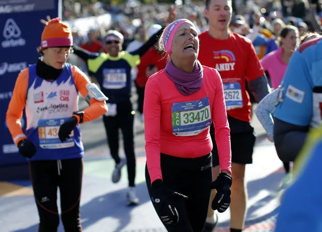 A runner reacts after crossing the finish line, November 2, 2014. (Photo by Mike Segar/Reuters)