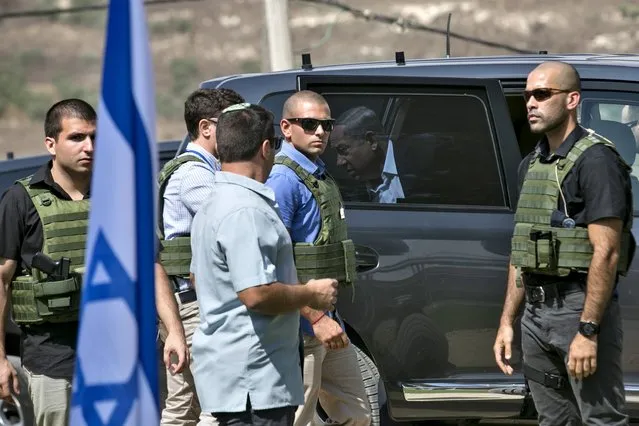 Israeli Prime Minister Benjamin Netanyahu (C) steps out of his car as bodyguards surround him while arriving to attend a meeting in an army base near the West Bank city of Nablus, October 6, 2015. Palestinian President Mahmoud Abbas said on Tuesday he did not want a spike in deadly violence in East Jerusalem and the Israeli-occupied West Bank to spiral into armed confrontation with Israel. (Photo by Baz Ratner/Reuters)