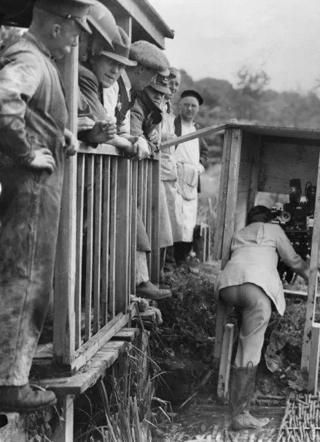 A group of British soldiers watch a cameraman filming the explosion of a bridge on Salisbury Plain, specially built to be blown up for a film about a battle between British troops and Chinese bandits, 15th July 1936. (Photo by Becker/Fox Photos/Getty Images)