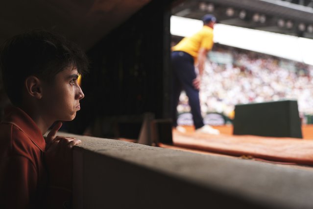 A ball boy follows the fourth round match of the French Tennis Open between China's Zheng Qinwen and Russia's Liudmila Samsonova, at the Roland-Garros stadium, in Paris, Sunday, June 1 2025. (Photo by Lindsey Wasson/AP Photo)