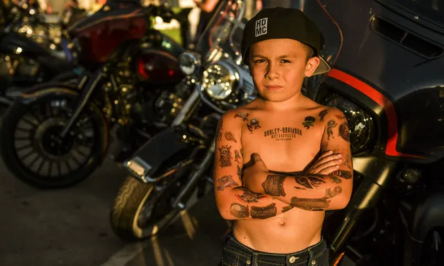 Covered in temporary tattoos, Josiah Sandoval, 7, stands for a portrait on Main Street during the 80th Annual Sturgis Motorcycle Rally in Sturgis, South Dakota on August 8, 2020. While the rally usually attracts around 500,000 people, officials estimate that more than 250,000 people may still show up to this year's festival despite the coronavirus pandemic. (Photo by Michael Ciaglo/Getty Images)
