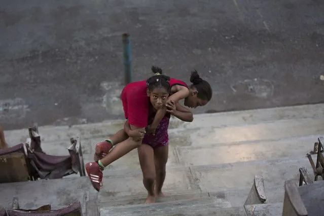 Children exercise before a wrestling practice session at an old Basque ball game gymnasium in downtown Havana, October 30, 2014. (Photo by Alexandre Meneghini/Reuters)