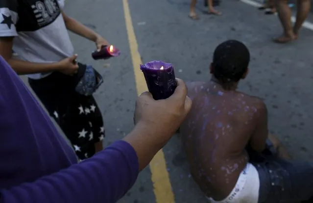 A worshipper pauses as fellows pour hot candle wax on his back during the annual celebratory pilgrimage in Portobelo, in the province of Colon October 21, 2015. (Photo by Carlos Jasso/Reuters)