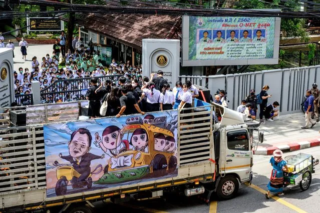 A student leaders speak from a truck with a banner featuring Thailand's Education Minister Nataphol Teepsuwan being chased by protesting schoolchildren during a protest in front of Samsen school demanding for less strict school rules, more tolerance and respect in Bangkok on October 2, 2020. (Photo by  Mladen Antonov/AFP Photo)