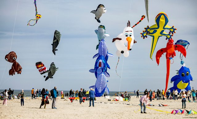 Visitors to the Baltic Sea beach fly kites over the sandy beach, in Laboe, Germany, on Saturday, April 6, 2024. (Photo by Axel Heimken/dpa via AP Photo)