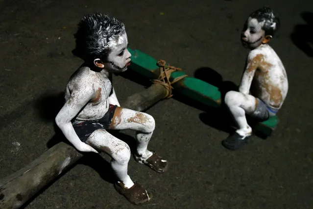 Two boys take part in a parade called “La Calabiuza” on November 1, 2017, on the eve of the Day of the Dead in Tonacatepeque, 20 kilometres north of San Salvador. During the celebration, the residents of Tonacatepeque, originally an indigenous community, recall the characters from the mythology of Cuscatlan – pre-Columbian west and central regions of El Salvador – and their dead relatives. (Photo by Marvin Recinos/AFP Photo)