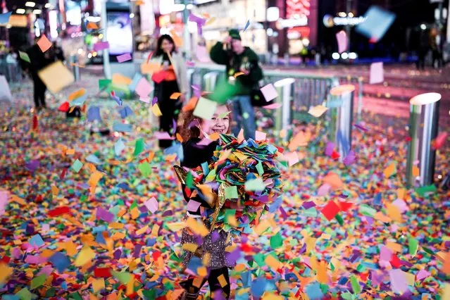 A child carries confetti as revelers gather during New Year's Eve celebrations in Times Square, as the Omicron coronavirus variant continues to spread, in the Manhattan borough of New York City, U.S., January 1, 2022. (Photo by Dieu-Nalio Chery/Reuters)
