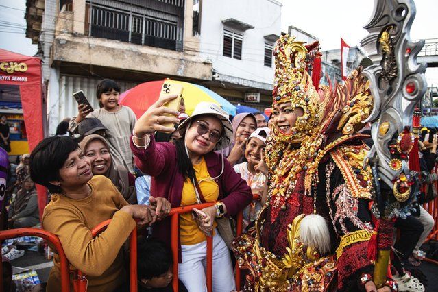 A model takes a selfie photo with the spectators during Greatwall of China show in the Grand Carnival on day 3 of the Jember Fashion Carnival 2025 on August 10, 2025 in Jember, Indonesia. (Photo by Robertus Pudyanto/Getty Images)