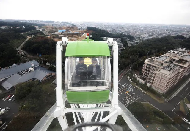 Fleq's president Tatsuki Yamamoto and his business partner use laptops while they have a meeting on a Ferris wheel at “Amusement Workation” where teleworkers can work from a Ferris wheel and pool side amid the coronavirus disease (COVID-19) outbreak, at Yomiuriland in Tokyo, Japan on October 15, 2020. (Photo by Kim Kyung-Hoon/Reuters)