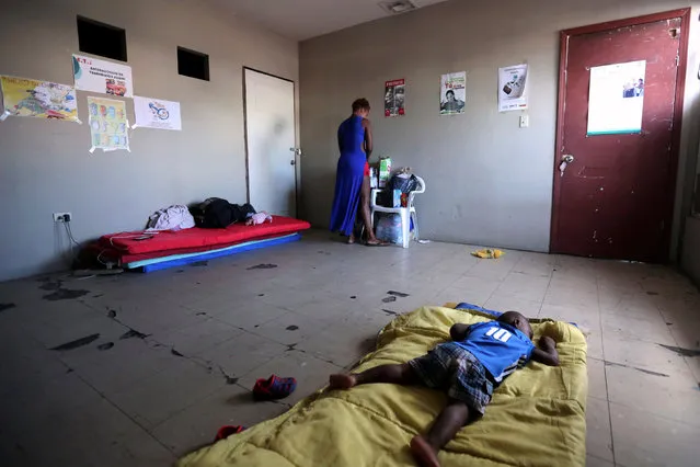 A Haitian migrant is seen as a child rests inside a shelter where they were relocated to after leaving Brazil due to Haiti's 2010 earthquake, in Mexicali, Mexico, October 5, 2016. (Photo by Edgard Garrido/Reuters)