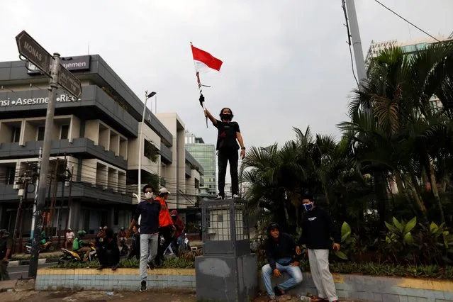 A demonstrator holds a flag during a protest against the new so-called omnibus law, in Jakarta, Indonesia, October 13, 2020. (Photo by Willy Kurniawan/Reuters)