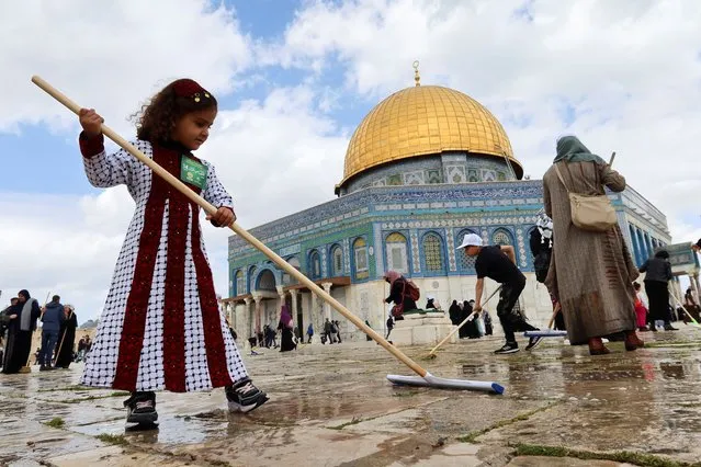 A Palestinian girl cleans the stone of the compound known to Muslims as the Noble Sanctuary and to Jews as the Temple Mount, in front of the Dome of the Rock, as part of preparations for the holy fasting month of Ramadan in Jerusalem's Old City, March 18, 2023. (Photo by Sinan Abu Mayzer/Reuters)