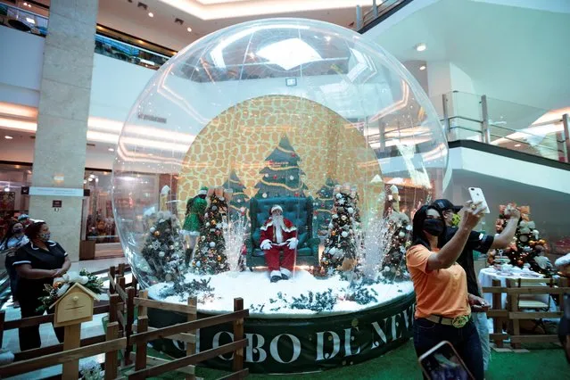 Abilio da Cruz Pinto, 77, dressed as a Santa Claus inside a plastic bubble is seen in a shopping mall amid the coronavirus outbreak in Brasilia, Brazil on December 15, 2020. (Photo by Adriano Machado/Reuters)
