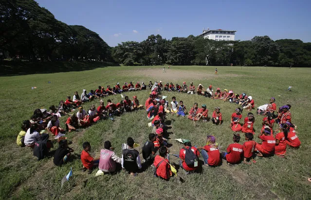Children from the Philippine indigenous peoples known as “Lumads” of southern Philippines participate in forming a human peace symbol during a cultural activity at the University of the Philippines in Quezon city, north of Manila, Philippines Tuesday October 25, 2016. The “Lumads” travelled to the country's capital some weeks ago to protest the alleged killings of some of their leaders by paramilitary forces as well as increased military presence in their ancestral lands. Their group were part of the demonstrators who got rammed by a police van during a brutal dispersal at the U.S. Embassy in Manila on Oct. 19. (Photo by Aaron Favila/AP Photo)