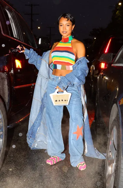 Karrueche Tran strikes a pose as she exits a Marni Event in Los Angeles on April 13, 2023. The 34 year old American actress and model wore a midriff baring multi-colored crop top under a long denim duster paired with distressed denim jeans, pink knitted moccasins and a Marni handbag. (Photo by The Image Direct)