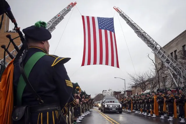 The hearse carrying NYPD officer Wenjian Liu makes its way under a U.S. flag en route to the cemetery in the Brooklyn borough of New York January 4, 2015. (Photo by Shannon Stapleton/Reuters)