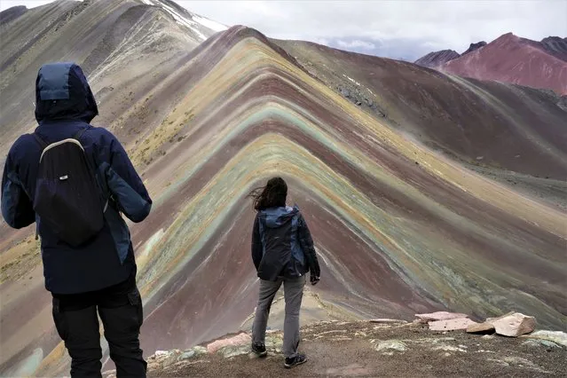 Tourists visit Rainbow Mountain in Cusipata, Peru, Sunday, February 5, 2023. The mountain is a bustling destination for international tourists but the number of visitors arriving in Peru has fallen due to the political unrest following President Pedro Castillo's impeachment and arrest for trying to close Congress in December of last year. (Photo by Rodrigo Abd/AP Photo)