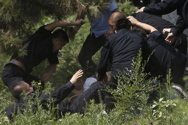 Police officers scuffle with protesting family members of victims of a fire that broke out in a chicken processing plant, outside the poultry slaughterhouse in Dehui, Jilin province, June 5, 2013. At least 120 people died, and more than 70 were injured when fire engulfed the chicken processing plant in rural northeast China. (Photo by Aly Song/Reuters)