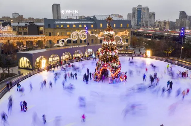 People ice skate around a Christmas tree in Kiev, Ukraine, on December 21, 2020. (Photo by Efrem Lukatsky/AP Photo)