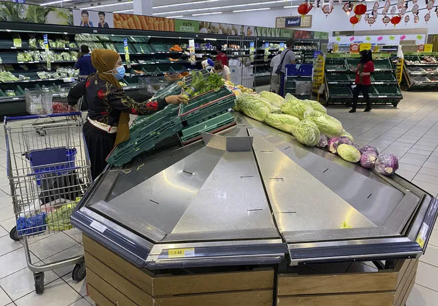 A woman shops for vegetables at a shopping mall in Kuala Lumpur, Malaysia, Tuesday, January 12, 2021. (Photo by Vincent Thian/AP Photo)