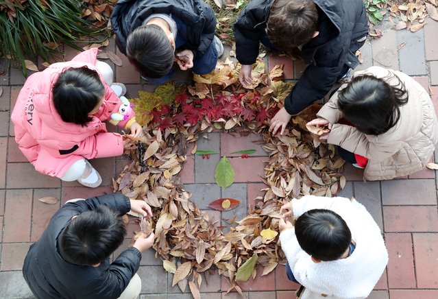 On the November 24, 2025, children are making human faces by collecting fallen leaves in the forest in front of the Yuseong-gu Office in Daejeon. (Photo by Shin Hyeon-jong)