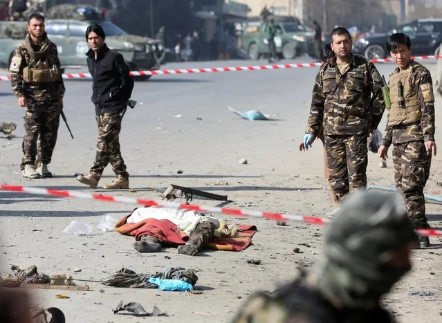 Afghan security forces inspect near a dead body of a victim after an explosion in Kabul, Afghanistan on February 6, 2021. (Photo by Omar Sobhani/Reuters)