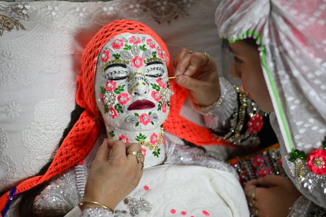 Bulgarian Pomak (Bulgarian speaking Muslims) bride Selve Kiselova , 21, has gelina make-up applied to her face ahead of her wedding ceremony in the village of Ribnovo, on December 29, 2024. The people of this Bulgarian mountain village are famous for performing their unique wedding ceremonies in winter time only. Muslim bulgarians are descendants of Christian bulgarians who were forcibly converted to Islam by the Turks, during the 14th, 16th and the 18th century. (Photo by Nikolay Doychinov/AFP Photo)