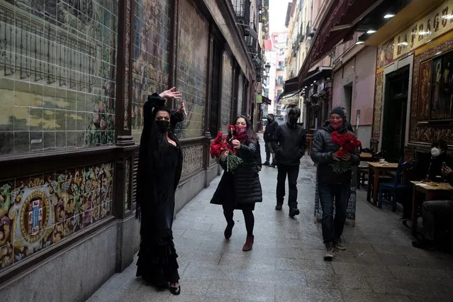 Spanish Flamenco dancer Anabel Moreno dances outside the Villa Rosa Tablao flamenco venue as a woman comes to give her a rose during a protest in Madrid, Spain, Thursday March 4, 2021. The National Association of Tablaos protested outside the mythical Villa Rosa Tablao which has been forced to close permanently due to the covid pandemic. (Photo by Paul White/AP Photo)