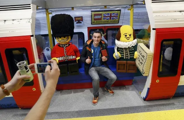 A man poses for a photograph in a Tube carriage made with Lego in the world's biggest Lego store in Leicester Square in London, Britain November 17, 2016. (Photo by Stefan Wermuth/Reuters)