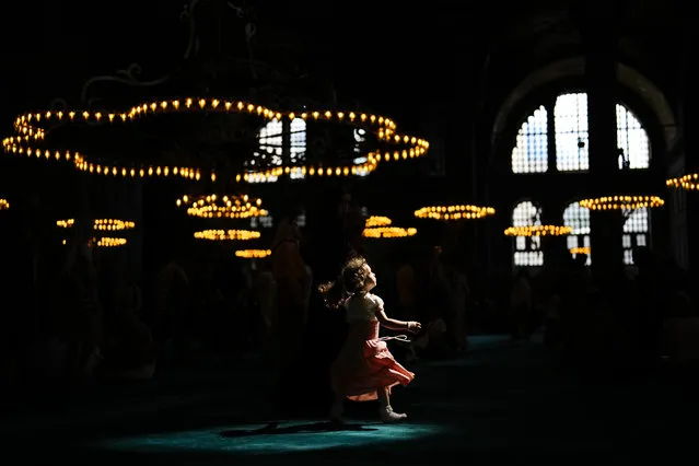 A child walks under a spot light at Byzantine-era Hagia Sophia mosque in Istanbul, Wednesday, July 5, 2023. (Photo by Francisco Seco/AP Photo)
