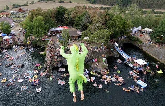 A competitor jumps into the water during a cliff diving competition near the central Bohemian village of Hrimezdice, Czech Republic, August 3, 2018. (Photo by David W. Cerny/Reuters)