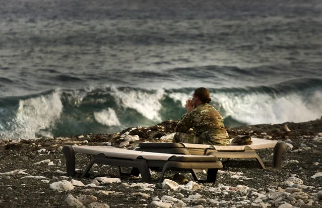 In this June 6, 2018 photo reviewed by U.S. military officials, a female army soldier looks out at the ocean from the Guantanamo Bay U.S. naval base in Cuba. A military judge presiding over the Sept. 11 war crimes proceedings ruled in 2016 that he would eventually lift his order prohibiting female guards from having physical contact with the five defendants. Prisoners lawyers' said contact with women unrelated to the defendants offended their Muslim beliefs. (Photo by Ramon Espinosa/AP Photo)