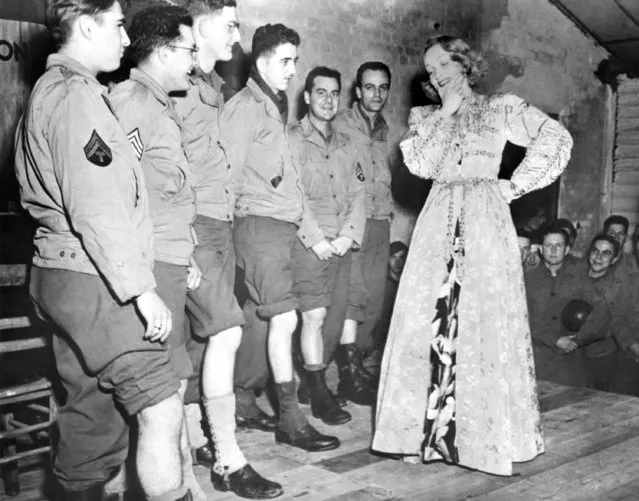 Screen actress Marlene Dietrich, left, tries to select the Queen of the chorus of the GI troupe during her visit to their camp at Namur, Belgium, November 30, 1944. The soldiers are, left to right: Cpl. Seaman Schlesinger, Philadelphia, Pa.; Sgt. Samuel Bonnvido, Warren, Pa.; Cpl. Thomas C. Vapehart, Indianapolis, Ind.; Pvt. Carl Fritz, Somersey, Pa.; Sgt. George Bagio, Cliffside Park, N.J., and Sgt. Dick Mullen, New York. (Photo by AP Photo)