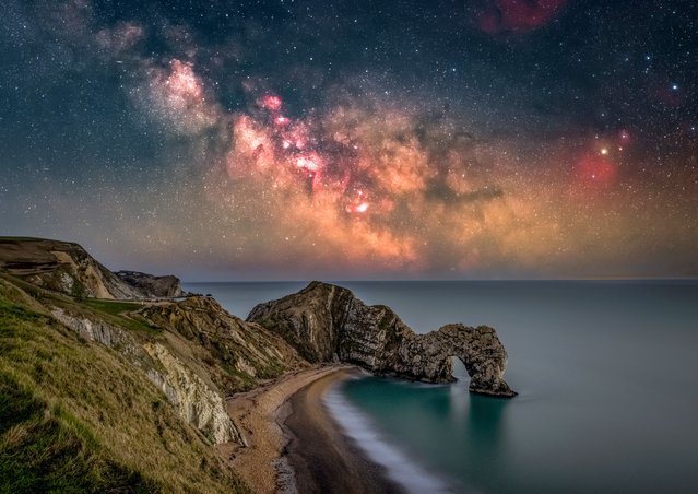 The Milky Way rising above Durdle Door in Dorset, United Kingdom on Saturday night, March 18, 2023. The image consists of 19 two-minute exposures, ten of the foreground and nine of the sky which needed a motorised star tracker to ensure the Milky Way wasn't blurry. All the photos were merged together to reveal more detail than what the naked eye can see. (Photo by Nick Bull/Picture Exclusive)