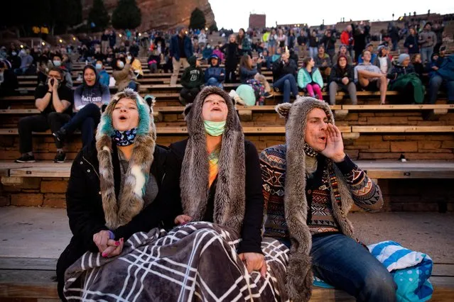 Anita Rose, Jim Galbreath and Dan Galbreath, participate in the “8 o'clock Howl” that honors essential workers at the 80th anniversary season kickoff at Red Rocks Amphitheatre as the coronavirus disease (COVID-19) restrictions are eased in Morrison, Colorado, U.S., April 28, 2021. (Photo by Alyson McClaran/Reuters)