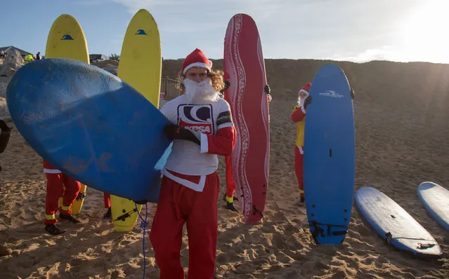 A surfer dressed as Santa gets ready to  brave the cold seas and near flat waves during the annual Surfing Santa as part of the Santa Run and Surf 2016 at Fistral Beach in Newquay on December 4, 2016 in Cornwall, England. (Photo by Matt Cardy/Getty Images)