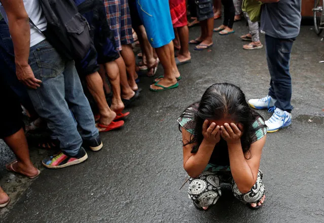 A family friend weeps after Nora Acielo, 47, was gunned down by unidentified men while escorting her two children to school in Manila, Philippines December 8, 2016. Police said Acielo was among more than 30 people slain over the last three days in drugs related killings. (Photo by Erik De Castro/Reuters)