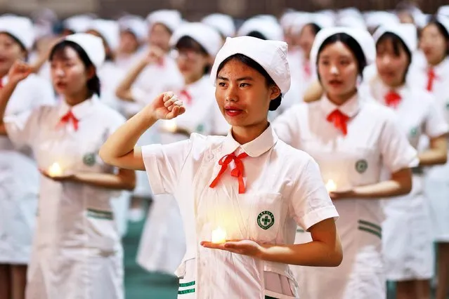 Nursing students make vows during a capping ceremony on International Nurses Day on May 12, 2021 in Taiyuan, Shanxi Province of China. International Nurses Day is observed annually on May 12. (Photo by Hu Yuanjia/VCG via Getty Images)