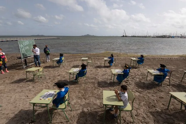Students from Colegio Felix Rodriguez de la Fuente attend their graduation ceremony on Los Nietos beach in the Mar Menor, where they have been developing their classes during the pandemic, on May 26, 2021 in Cartagena, Spain. The open-air learning is part of the Felix Rodriguez de la Fuente school's program of creating healthier environments for school children during the COVID-19 pandemic. (Photo by Alfonso Duran/Getty Images)