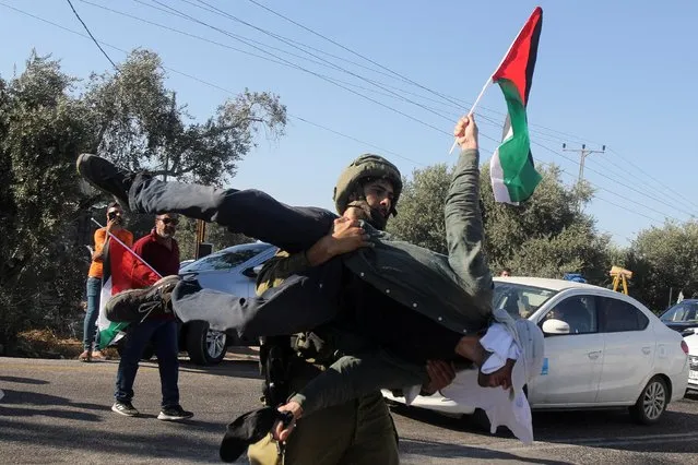 An Israeli soldier carries an activist during the suppression of the protest against Israeli settlement activity in Salfit, in the Israeli-occupied West Bank, July 27, 2022. (Photo by Raneen Sawafta/Reuters)