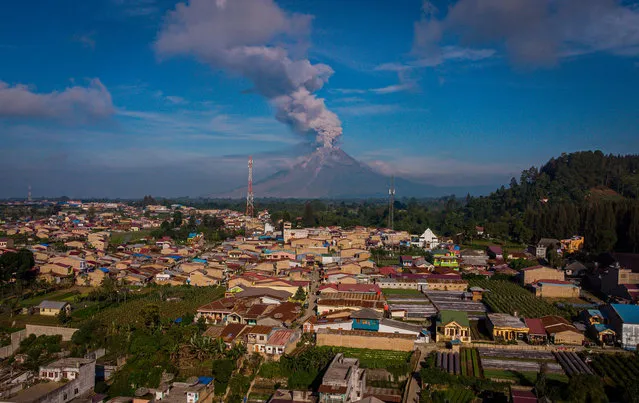 This aerial photo taken on May 10, 2021 shows Mount Sinabung spewing hot ash and smoke into the sky, seen from Karo, North Sumatra. (Photo by Tibta Nangin/AFP Photo)
