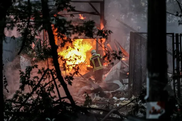 Ukrainian rescue service members work at the site of a missile strike on a residential area, in Kyiv, Ukraine, 21 September 2023. “Damage was recorded in Darnytskyi, Solomyanskyi, Shevchenkivskyi districts in Kyiv as a result of falling missiles’ pieces. Fires broke out in Darnytskyi District. Seven people were wounded, including a child” says Ihor Klymenko, Ukraine's Minister of Internal Affairs. (Photo by Oleg Petrasyuk/EPA/EFE)