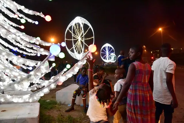 Residents enjoy an evening stroll on December 29, 2016 in the business district of Plateau d'Abidjan decorated for Chrismas and New Year's celebrations. (Photo by Issouf Sanogo/AFP Photo)