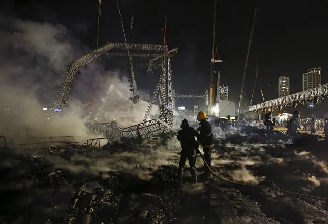 Firefighters try to extinguish a fire at the venue of a cultural event during “Make in India” week in Mumbai, India, February 14, 2016. A huge fire engulfed the venue of a cultural event in Mumbai on Sunday that was being held at the opening of a “Make in India” week launched by Prime Minister Narendra Modi to drum up foreign investment. (Photo by Danish Siddiqui/Reuters)