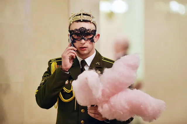 A Belarus' military cadet holds cotton candy while speaking on his mobile phone during the Big New Year Ball at the Bolshoi Opera and Ballet Theatre in Minsk late on January 13, 2019. (Photo by Sergei Gapon/AFP Photo)