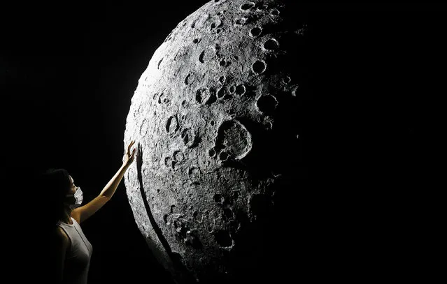 The visitor touch to model of moon during Explore CASCI (China Aerospace Science and Cultural Innovation) ART Exhibition on October 2, 2022 in Wuhan, Hubei province, China. China is celebrating its 73nd National Day and a week-long holiday known as the “Golden Week”. (Photo by Getty Images）