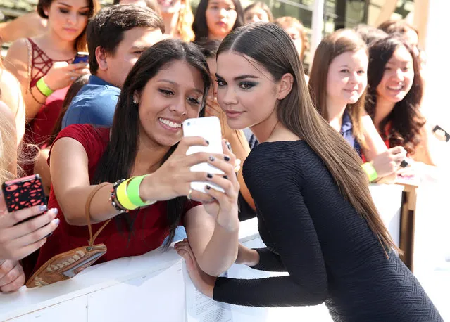 Maia Mitchell takes a selfie with fans as she arrives at the MTV Movie Awards at the Nokia Theatre on Sunday, April 12, 2015, in Los Angeles. (Photo by Matt Sayles/Invision/AP Photo)
