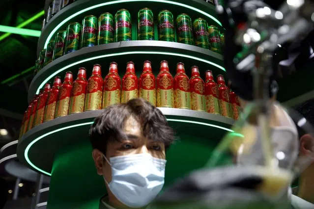 A staff member fills a cup of beer at the Tsingtao booth during the first China International Supply Chain Expo (CISCE) in Beijing, China on November 28, 2023. (Photo by Florence Lo/Reuters)