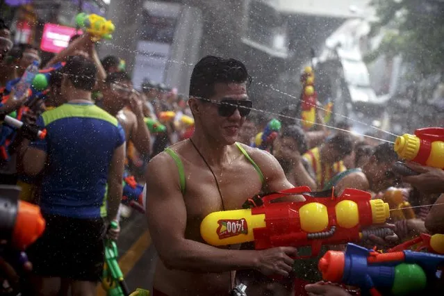 Revellers use water guns as they participate in a water fight during Songkran Festival celebrations at Silom road in Bangkok April 13, 2015. (Photo by Athit Perawongmetha/Reuters)